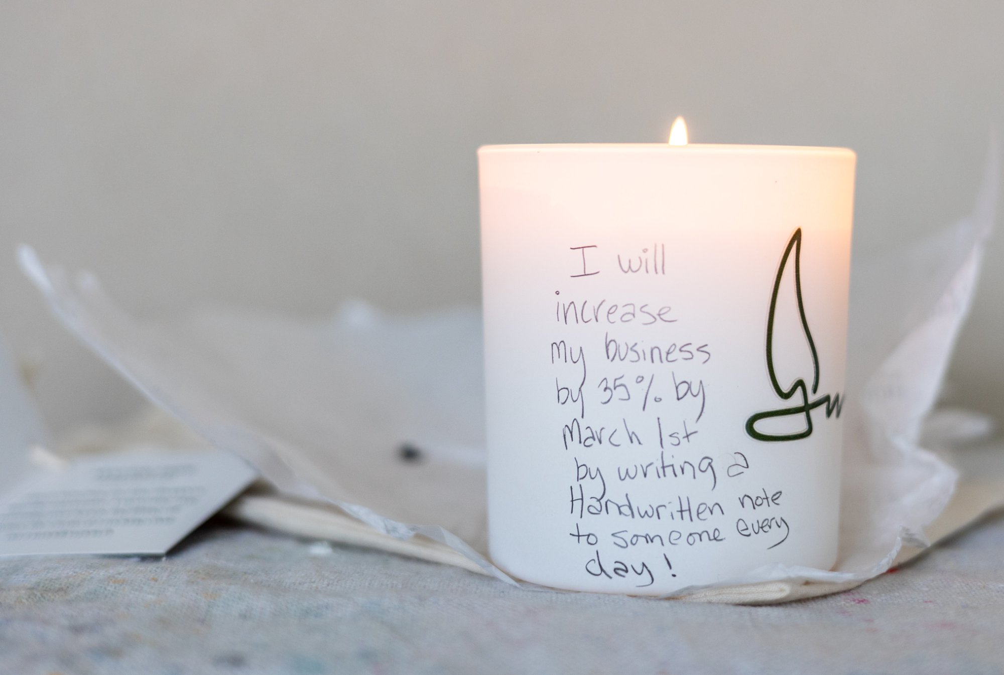 Candle burning with intention written