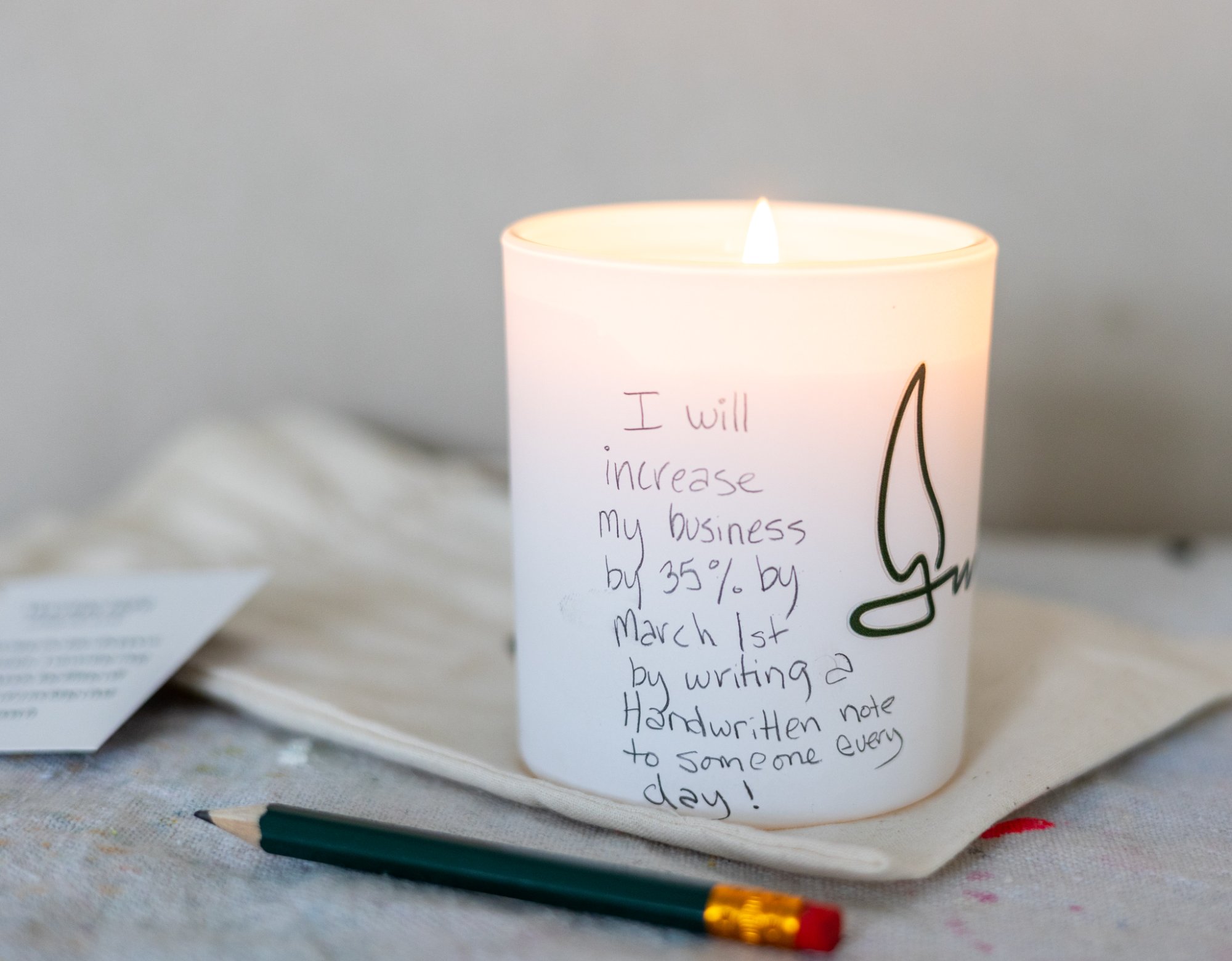 Manifestation Candle lit with intention written on it